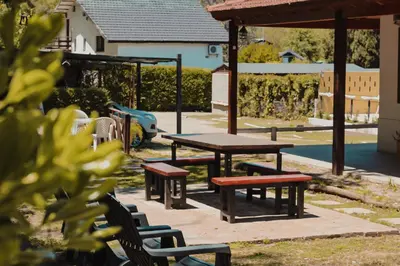 a picnic table and benches in a park at Posada Ojo de Agua Villa General Belgrano in Villa General Belgrano