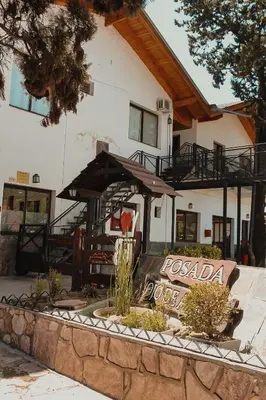 a building with a sign in front of it at Posada Ojo de Agua Villa General Belgrano in Villa General Belgrano