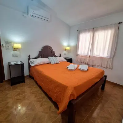 a bedroom with a large bed with two towels on it at Posada Ojo de Agua Villa General Belgrano in Villa General Belgrano