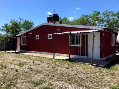 a red and white house with a yard in front of it at Cabañas la soñada de T in Tanti