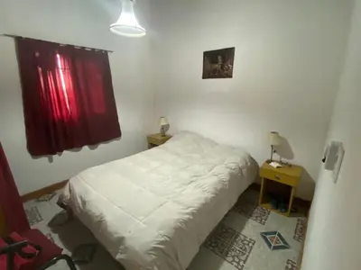 a bedroom with a white bed and a window at Cabañas la soñada de T in Tanti