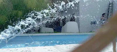 a fountain in a pool with water shooting into the air at Güemes Hostel Cordoba in Cordoba