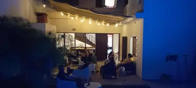 a group of people sitting in a living room at night at Güemes Hostel Cordoba in Cordoba