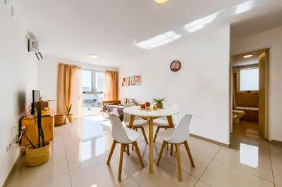 a dining room with a table and white chairs at Un Rinconcito en Guemes - Confort y Calidez in Cordoba