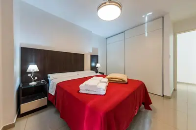a bedroom with a large bed with a red blanket at Un Rinconcito en Guemes - Confort y Calidez in Cordoba