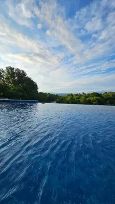 a large body of water with trees in the background at El Potrerillo Posada in Santa Rosa de Calamuchita