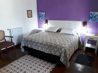 a bedroom with a large bed and a chair at El Potrerillo Posada in Santa Rosa de Calamuchita