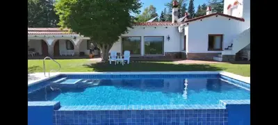a villa with a swimming pool in front of a house at El Potrerillo Posada in Santa Rosa de Calamuchita