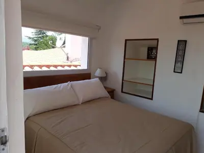 a small bedroom with a bed and a window at El Potrerillo Posada in Santa Rosa de Calamuchita