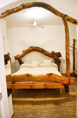 a bedroom with a bed made out of logs at Casitas de Norma in Embalse