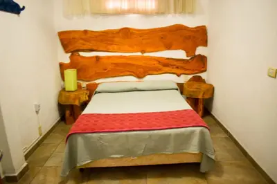 a bedroom with a bed with a wooden headboard at Casitas de Norma in Embalse