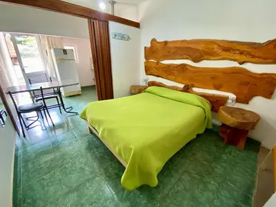 a bedroom with a green bed and a table at Casitas de Norma in Embalse