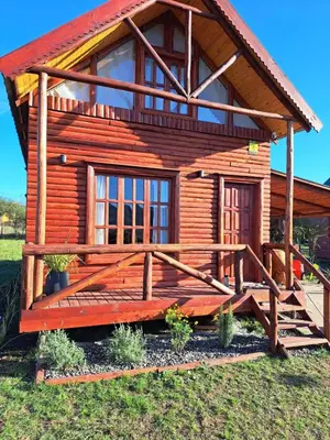 a log cabin with a porch and a deck at Cabaña en Los Reartes in Villa General Belgrano