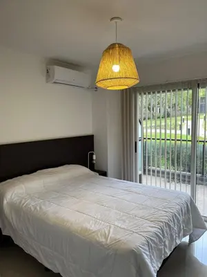 a bedroom with a large bed and a large window at Departamento Veneto Village - D - in Villa Parque Siquiman