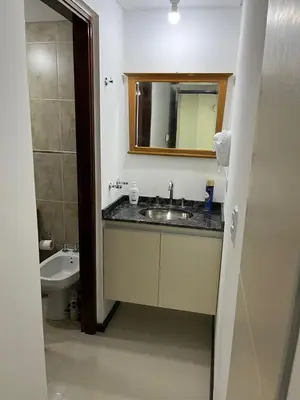 a bathroom with a sink and a toilet and a mirror at Departamento Veneto Village - D - in Villa Parque Siquiman