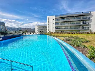 a large swimming pool in front of a building at Departamento Veneto Village - D - in Villa Parque Siquiman