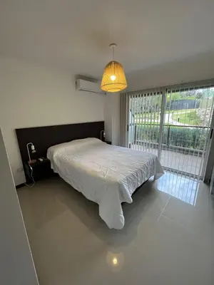 a bedroom with a bed and a large window at Departamento Veneto Village - D - in Villa Parque Siquiman