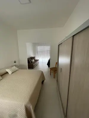 a white bedroom with a bed and a couch at Departamento céntrico y espacioso en Río Cuarto II in Río Cuarto