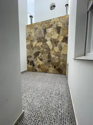 a bathroom with a shower with a stone wall at Departamento céntrico y espacioso en Río Cuarto II in Río Cuarto