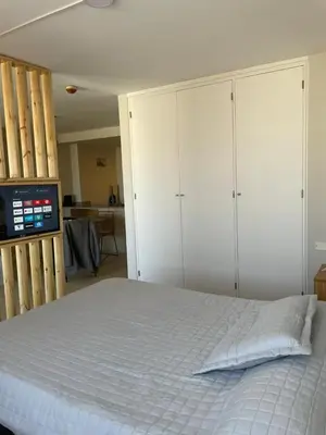 a bedroom with a bed with white cabinets and a tv at Coral State in Cordoba