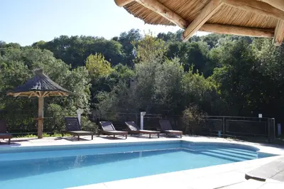 a swimming pool with chairs and a gazebo at Cabañas Bosque Encantado in Merlo