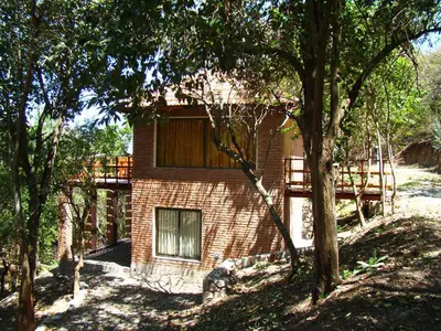a brick building with a deck on top of it at Cabañas Bosque Encantado in Merlo