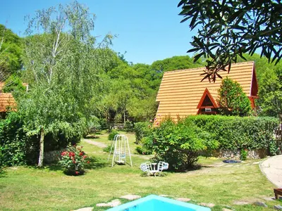 a yard with a playground and a house at Cabañas Bosque Encantado in Merlo
