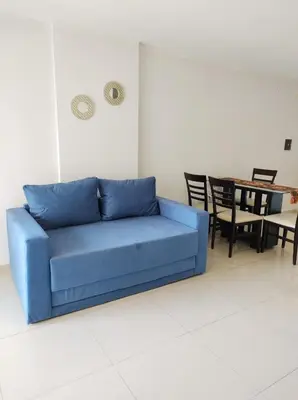 a blue couch in a living room with a table at Departamento Skala in Cordoba