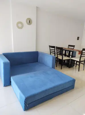 a blue couch in a living room with a table at Departamento Skala in Cordoba