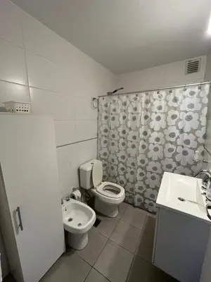 a bathroom with a toilet and a shower curtain at Departamento Skala in Cordoba