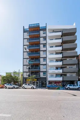 a large apartment building with cars parked in front of it at 24 de Septiembre 1859 B Gral Paz in Cordoba
