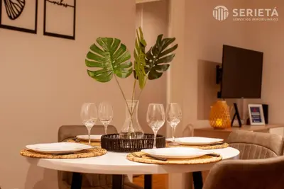 a table with plates and glasses and a plant on it at SERIETÁ Frente al PARQUE SARMIENTO in Cordoba