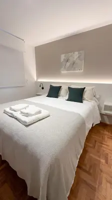a bedroom with a large white bed with green pillows at SERIETÁ Frente al PARQUE SARMIENTO in Cordoba