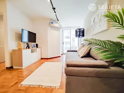 a living room with a couch and a tv at SERIETÁ Frente al PARQUE SARMIENTO in Cordoba