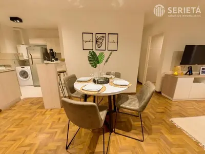 a dining room with a table and chairs and a kitchen at SERIETÁ Frente al PARQUE SARMIENTO in Cordoba