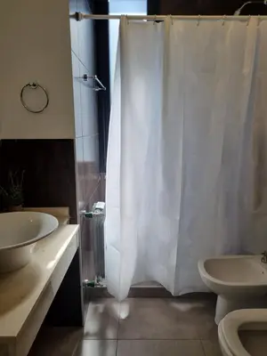 a bathroom with a white shower curtain and a sink at PRISMA CUARENTA in Villa Carlos Paz