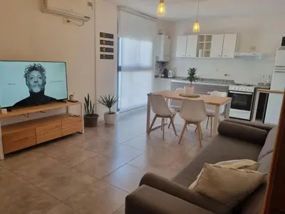 a living room with a couch and a tv and a table at PRISMA CUARENTA in Villa Carlos Paz
