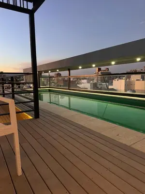 a deck with a swimming pool on top of a building at PRISMA CUARENTA in Villa Carlos Paz
