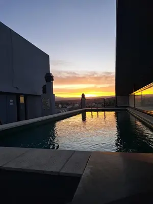 a swimming pool with a sunset in the background at PRISMA CUARENTA in Villa Carlos Paz