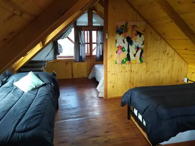 a room with two beds in a attic at Cabañas en los reartes in Los Reartes