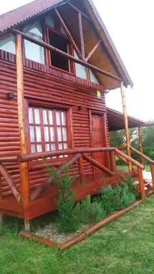 a large log cabin with a porch and a porch at Cabañas en los reartes in Los Reartes