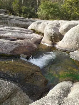 a stream of water on the rocks in a river at Cabañas en los reartes in Los Reartes