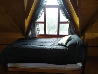 a bed in a room with a window at Cabañas en los reartes in Los Reartes