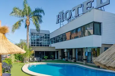 a hotel with a swimming pool in front of a building at Hotel Sialdorf in Villa Carlos Paz