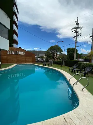 a large swimming pool in front of a building at Hotel Sialdorf in Villa Carlos Paz