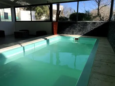 a swimming pool with blue water in a house at Hotel Sialdorf in Villa Carlos Paz