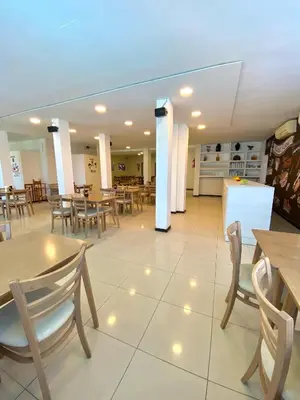 a restaurant with wooden tables and chairs and tablesktop at Hotel Sialdorf in Villa Carlos Paz