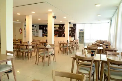 a dining room with wooden tables and chairs at Hotel Sialdorf in Villa Carlos Paz
