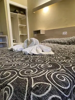 a hotel room with a bed with a towel on it at Hotel Sialdorf in Villa Carlos Paz
