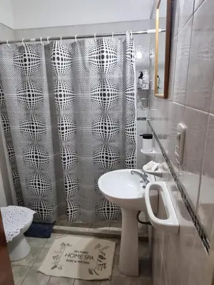 a bathroom with a shower curtain and a sink at Home in Río Cuarto
